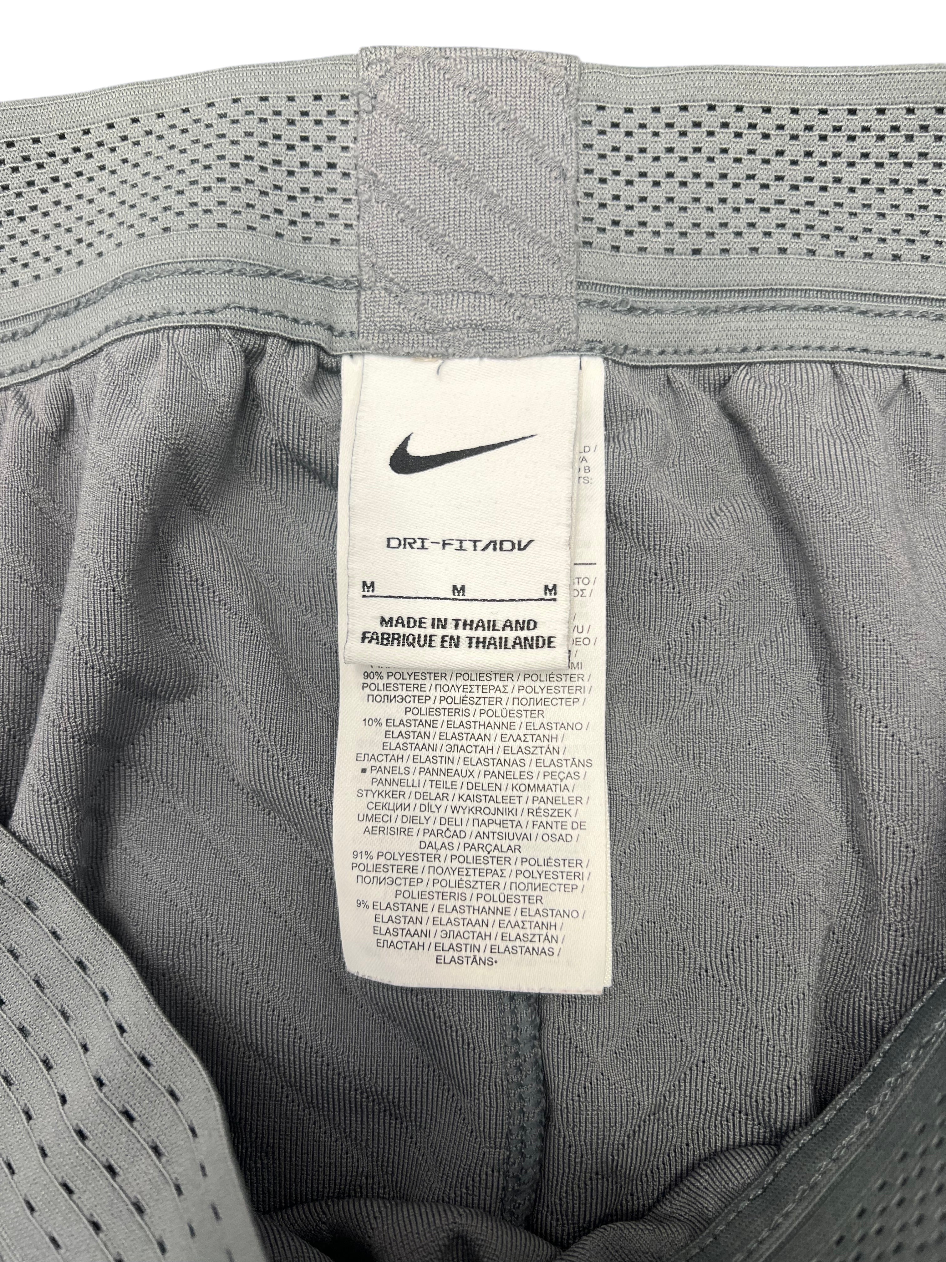 kitround Liverpool FC Men's grey training bottoms with Dri-FIT ADV technology, geometric pattern, elasticated waistband, and zipped ankles. Polyester/elastane blend.