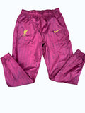 Liverpool FC Nike lightweight training trousers in deep red with all-over subtle print and yellow crest/swoosh embroidery.