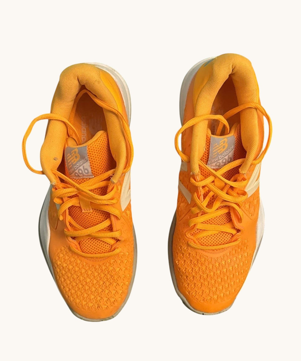 Vibrant orange New Balance 996 tennis shoes with white accents and a herringbone sole pattern. Lightly used.
