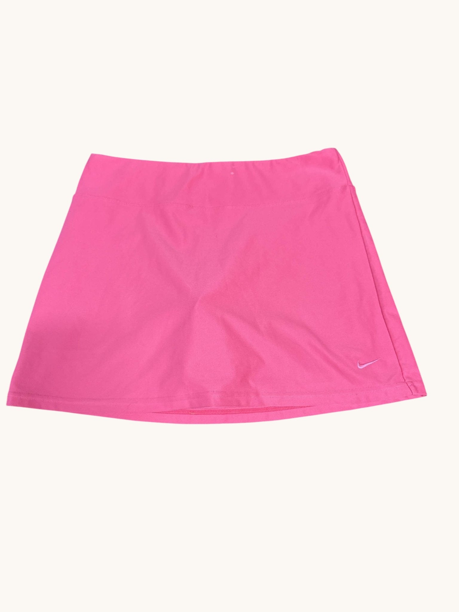 Nike women's bright pink tennis skirt with a small embroidered swoosh logo on the hem. Lightweight and breathable.