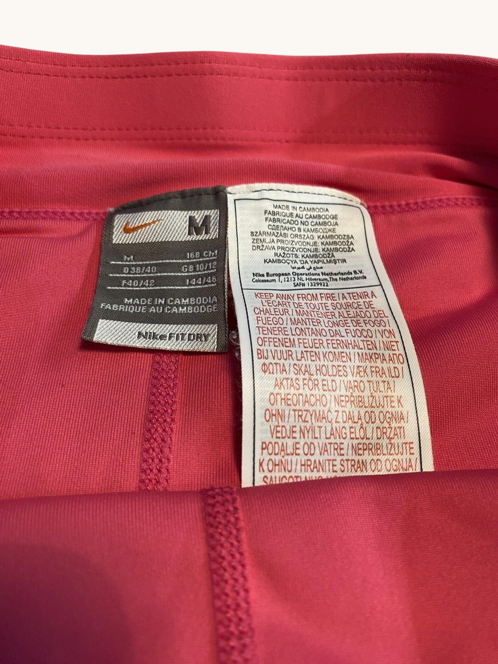 Nike pink tennis skirt with white trim and swoosh logo. Made from breathable fabric for comfort and movement.
