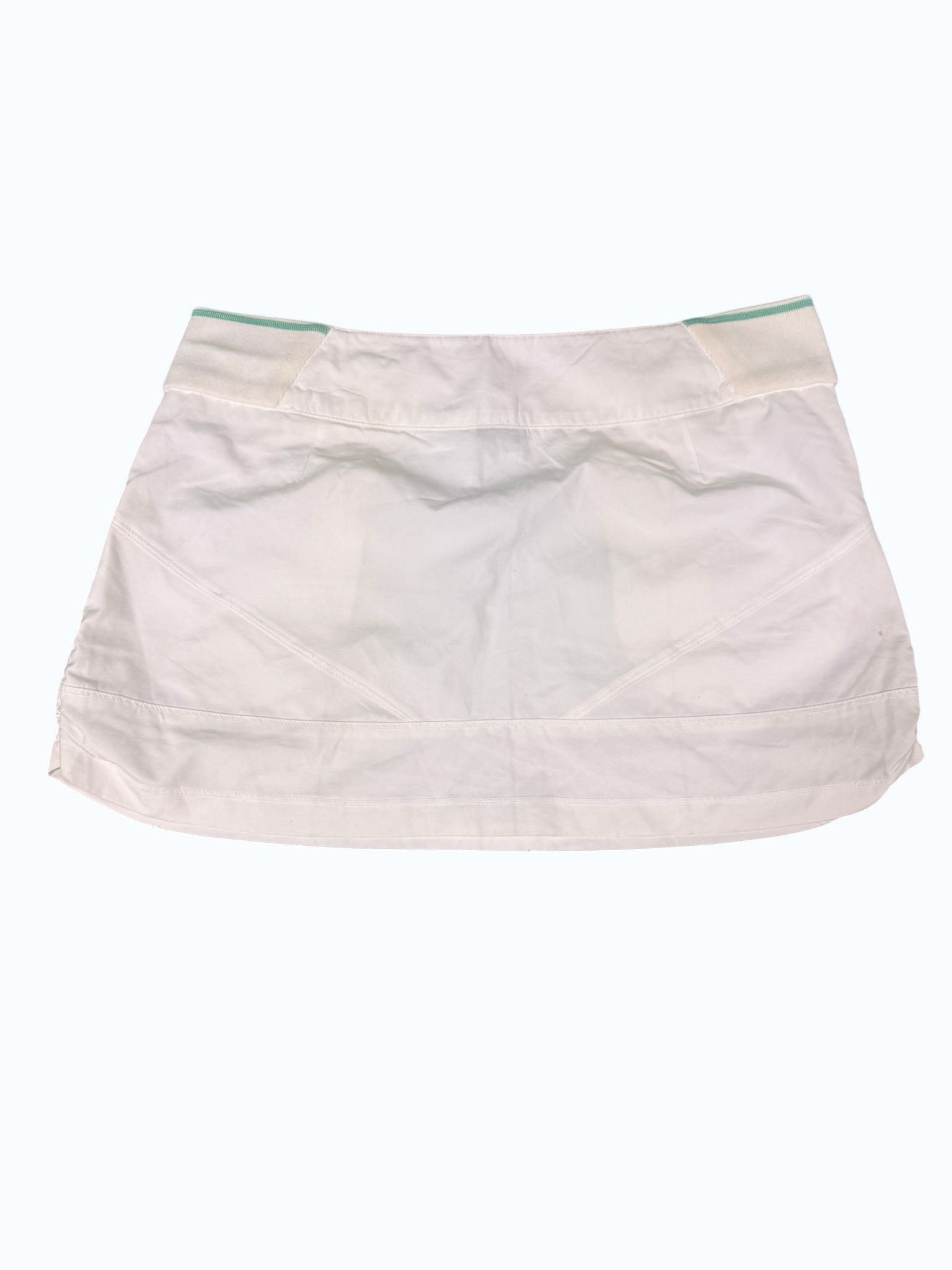 Kitround Nike white tennis skirt with green trim waistband and side pockets. Lightweight, breathable fabric for comfort and movement.