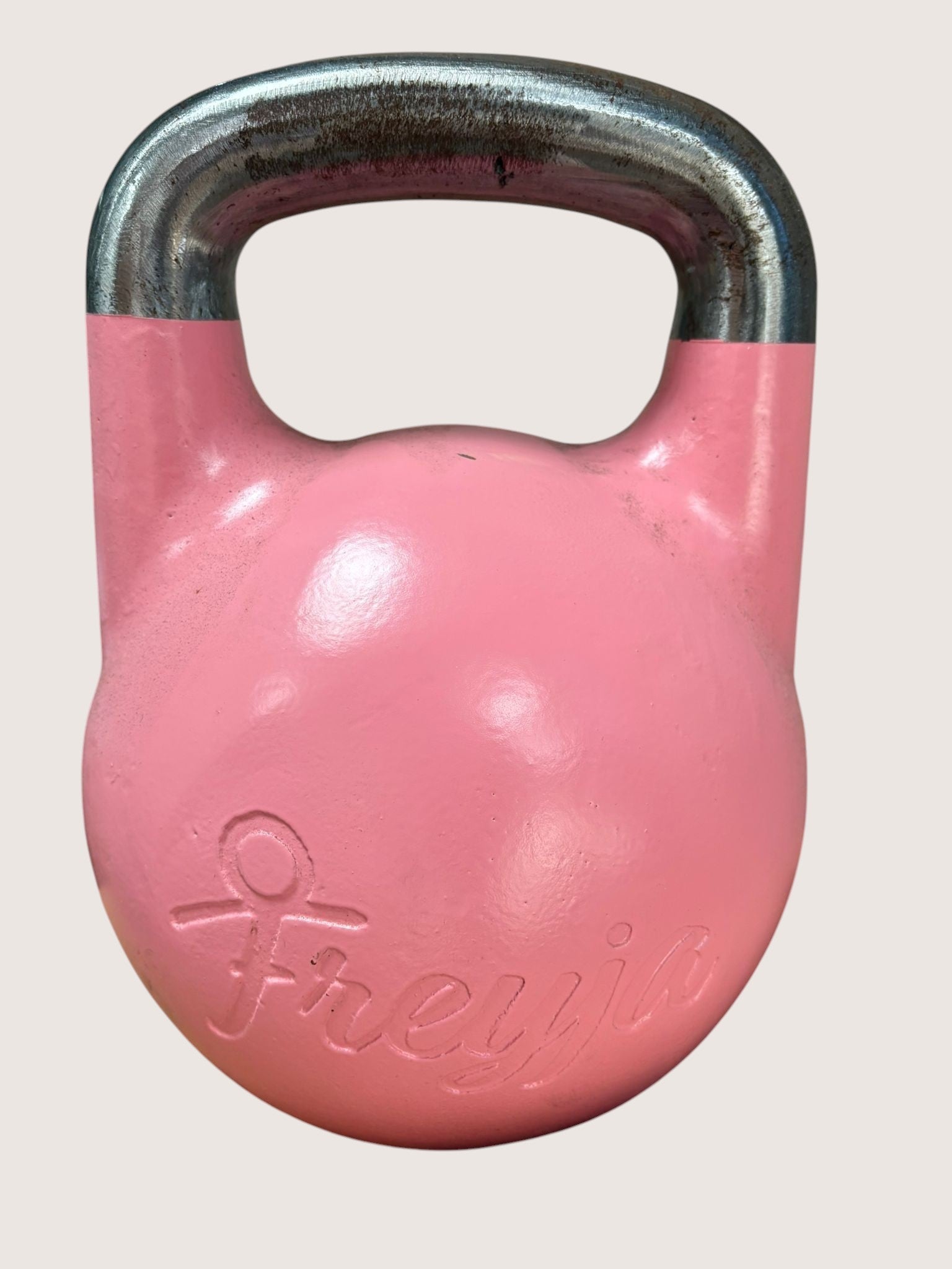 12kg pink cast iron kettlebell by Freyja with a silver handle. Features a flat base and embossed logo.