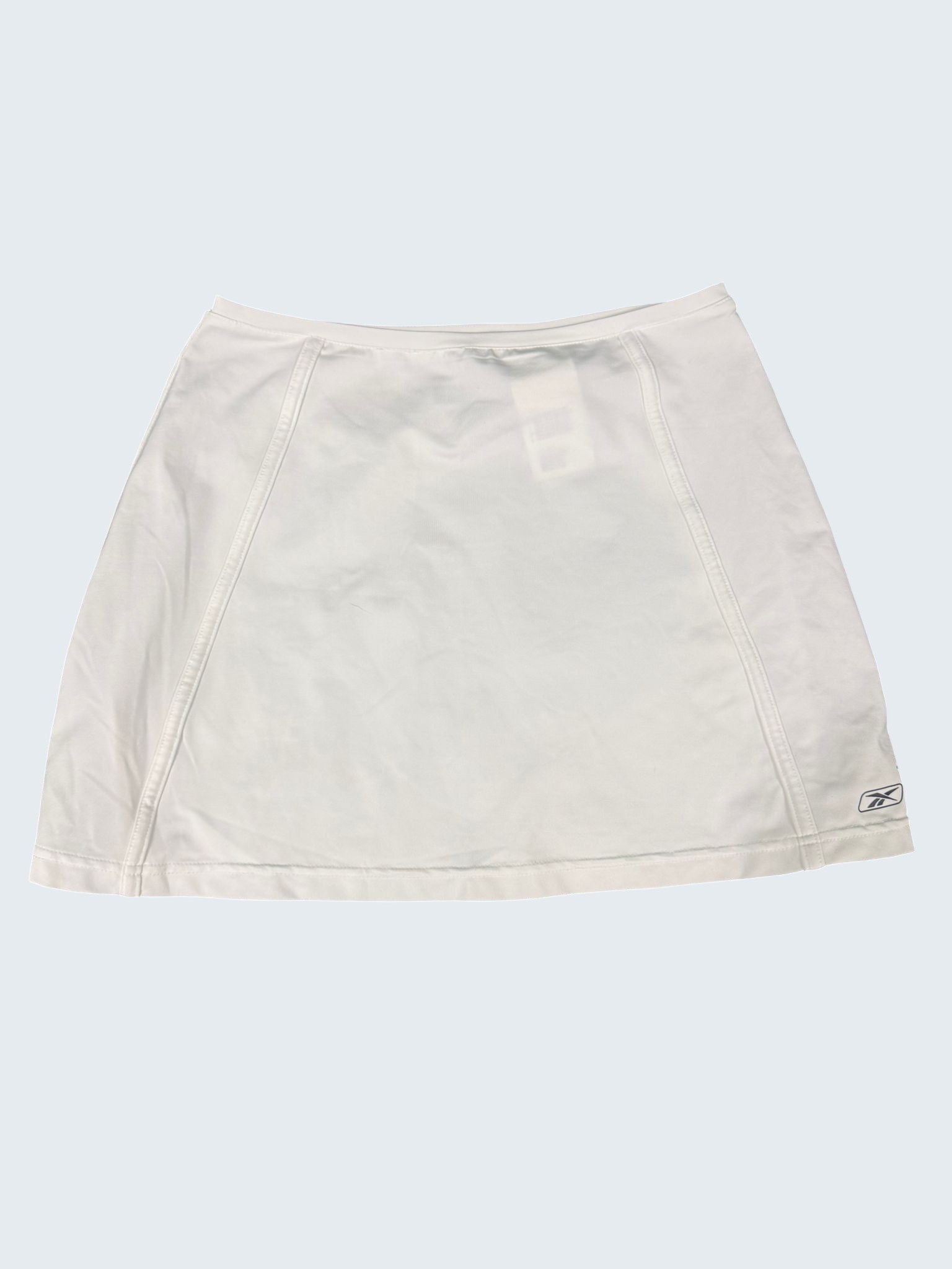 Reebok women's white A-line tennis skirt with subtle stitching and logo detail. Size M.