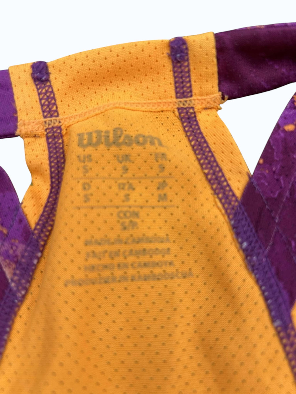 Wilson athletic jersey in orange with purple trim and detailing. Lightweight, breathable fabric, ideal for basketball.