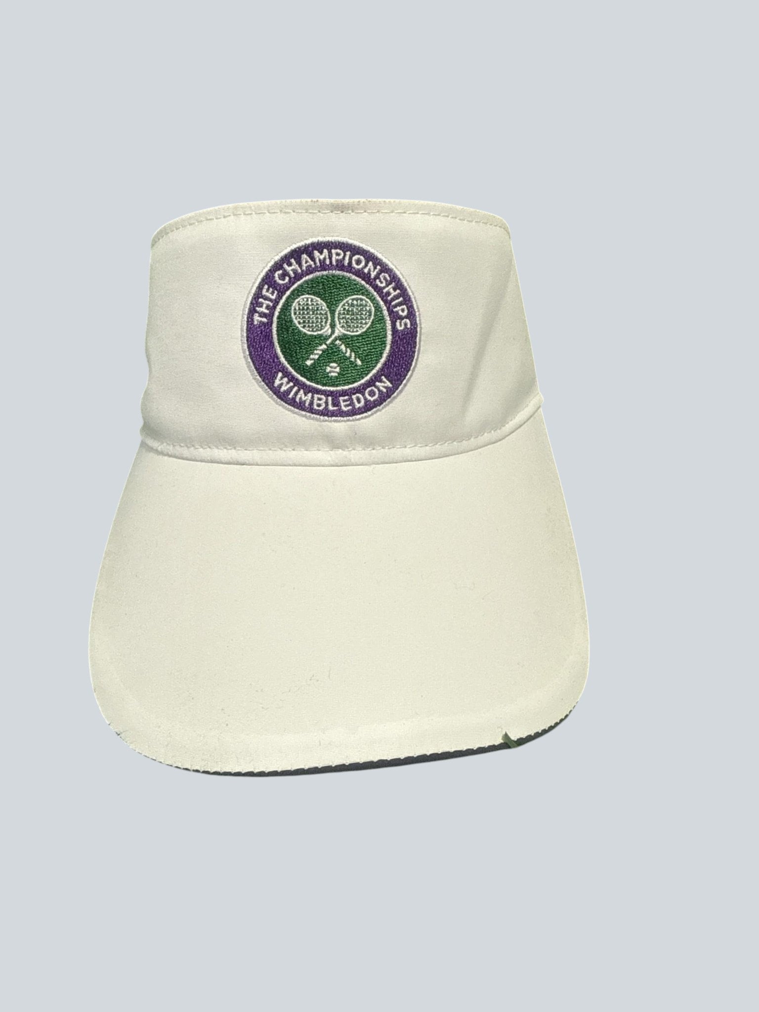 Official kitround Wimbledon tennis visor in white, featuring the iconic Wimbledon Championships logo embroidered in purple and green. Adjustable for a comfortable fit.