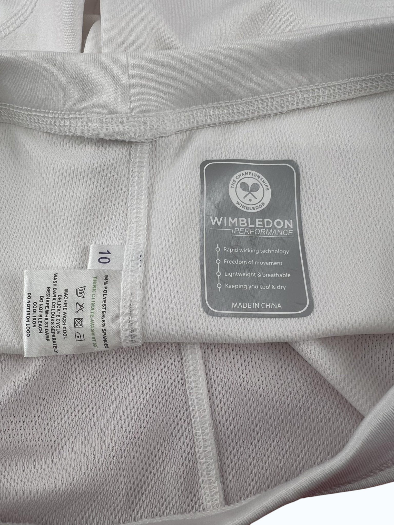 kitround Women's white tennis shorts with Wimbledon Performance logo tag, made from 94% polyester and 6% spandex.