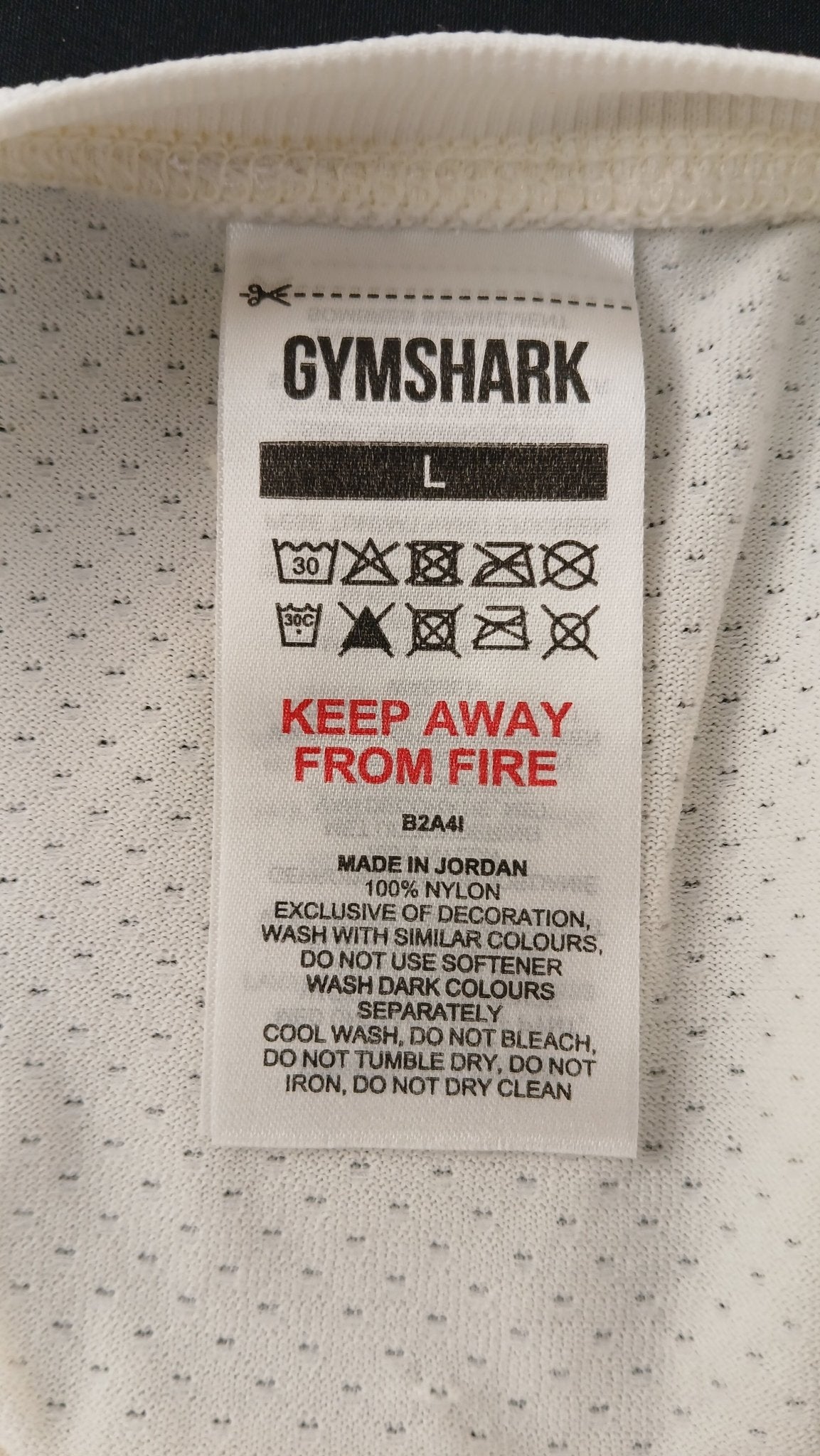 Label showing care instructions and size L on Gymshark T-shirt