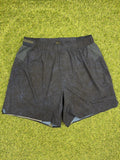 Front view of Lululemon men's dark athletic shorts with elastic waistband