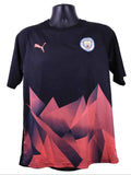 Front view of Puma Manchester City pre-match football shirt with black base and red geometric design