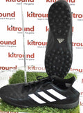 adidas black astro turf football boots with white stripes, shown side and sole view on artificial grass