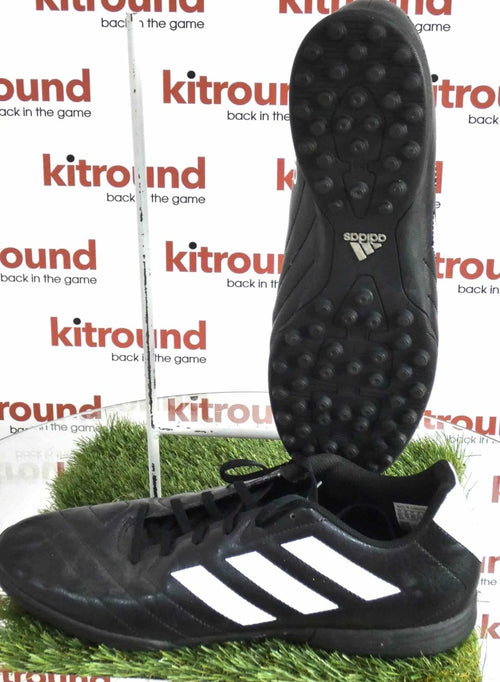 adidas black astro turf football boots with white stripes, shown side and sole view on artificial grass