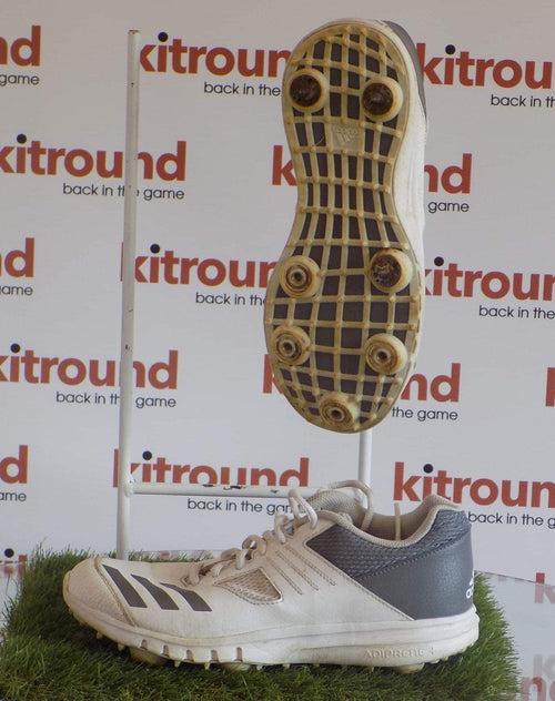 Side and underside view of adidas cricket spikes in white and grey with visible Adiprene branding
