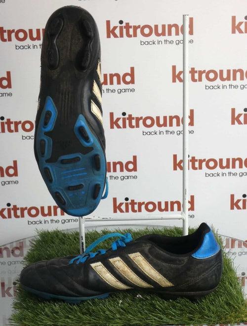 Pair of black adidas football boots with blue soles and white stripes, side and sole view on artificial grass with kitround branding.