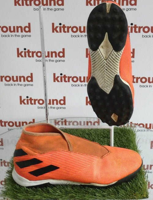 Side and sole view of adidas Nemesis orange astro football boots on artificial grass