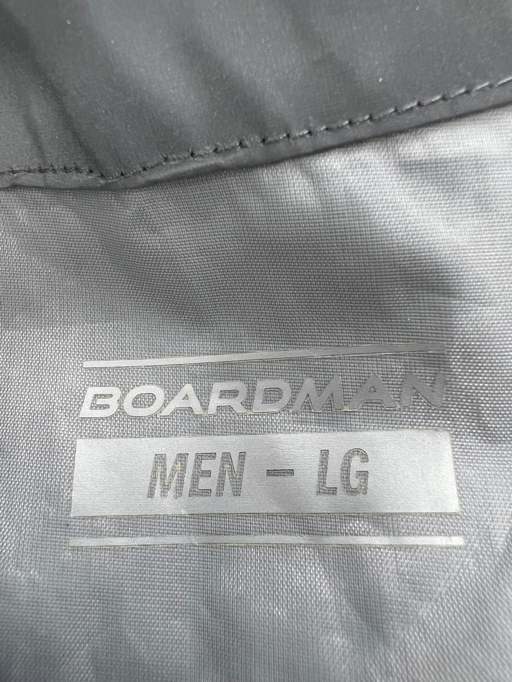 Close up of the inside label on Men’s Boardman grey reflective cycling jacket, showing brand and size