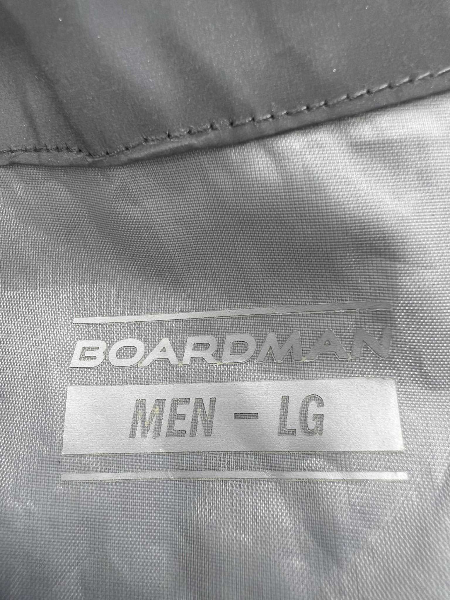 Close up of the inside label on Men’s Boardman grey reflective cycling jacket, showing brand and size