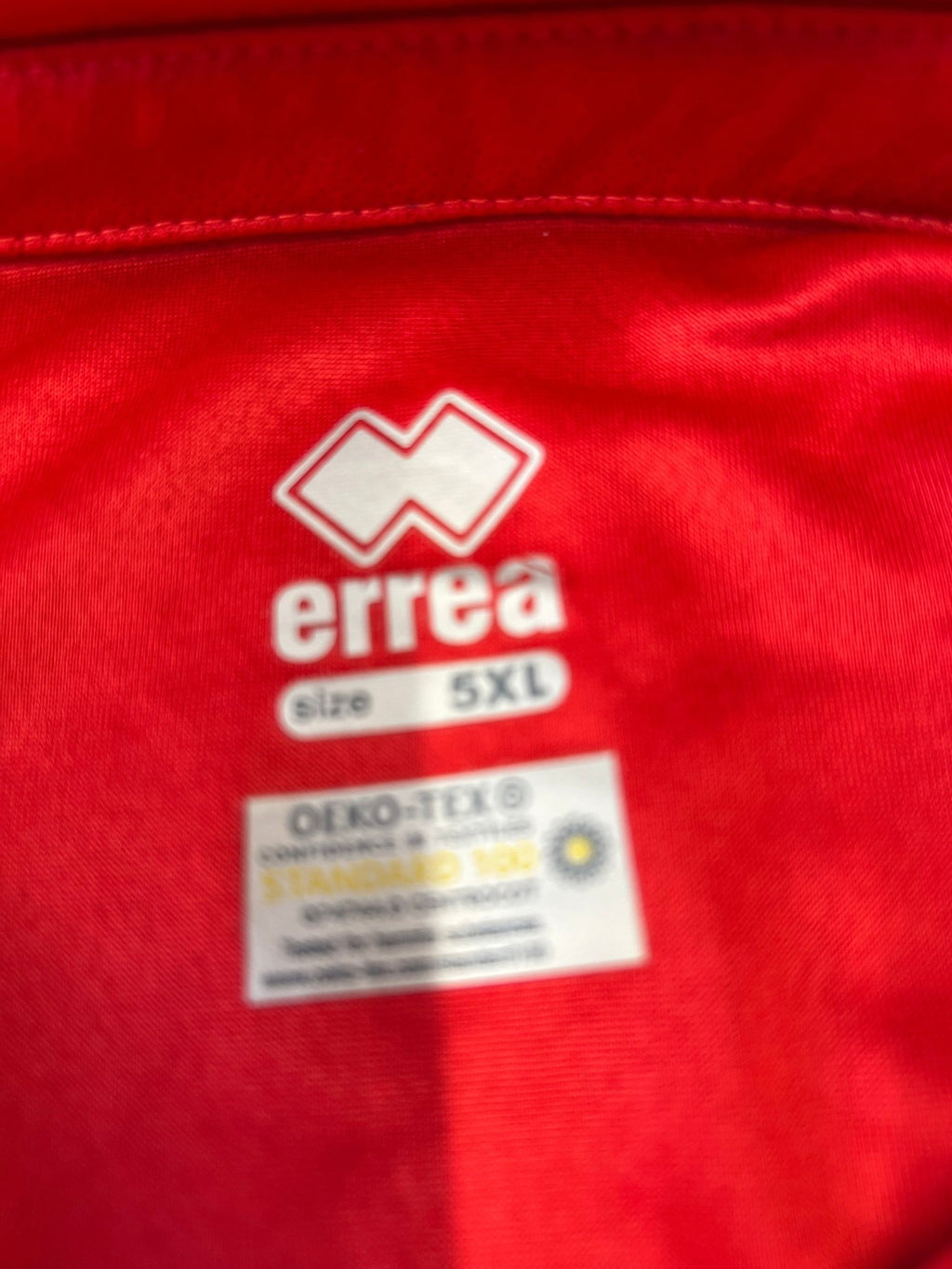 Close-up of men’s red England volleyball polo shirt size label showing Erreà 5XL and OEKO-TEX certification