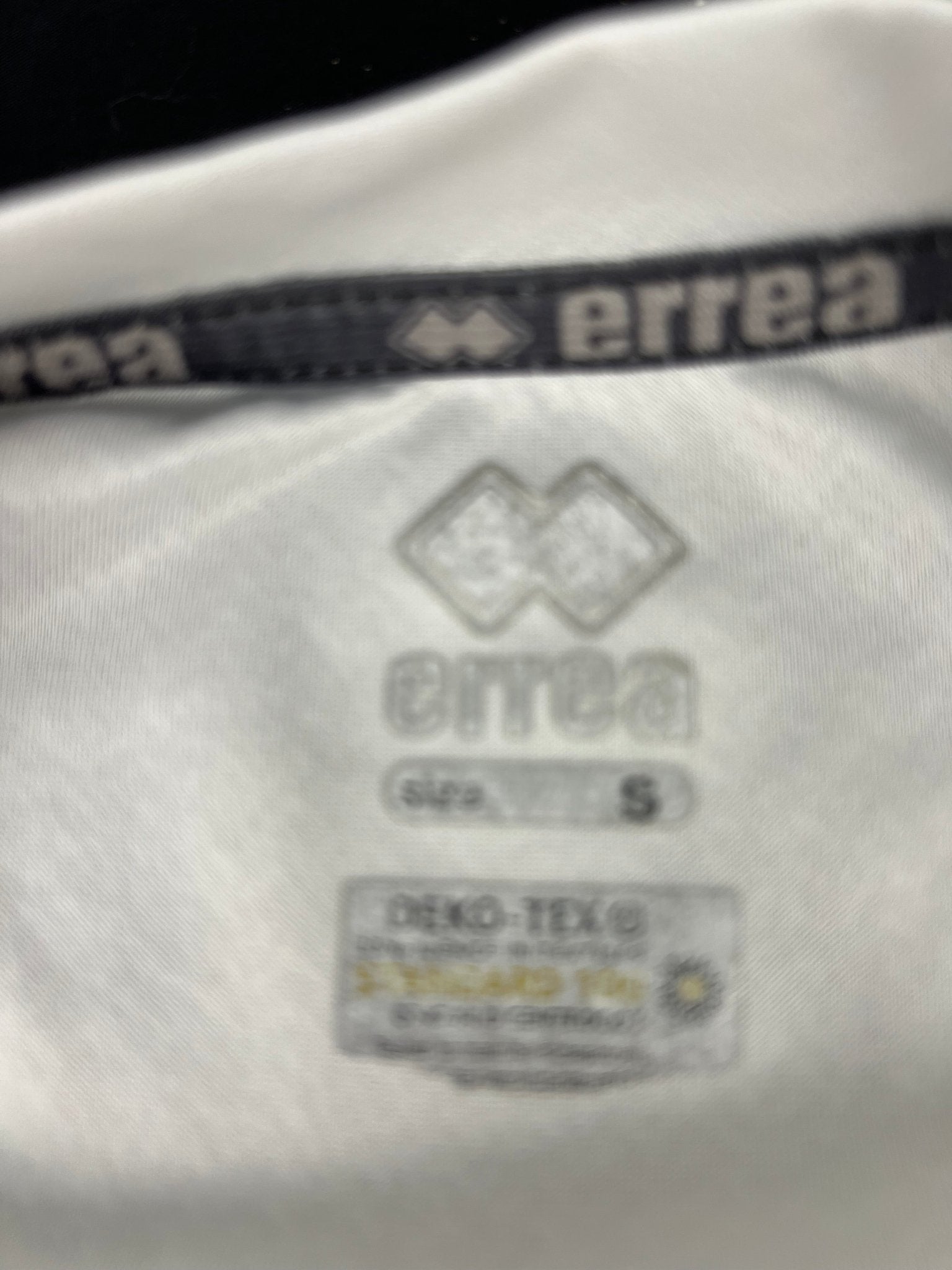 Close-up of inside tag showing Errea logo, size S, and OEKO-TEX certification on Men’s Volleyball T-shirt