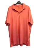 Front view of Puma coral short-sleeved XXL polo shirt hanging on a door