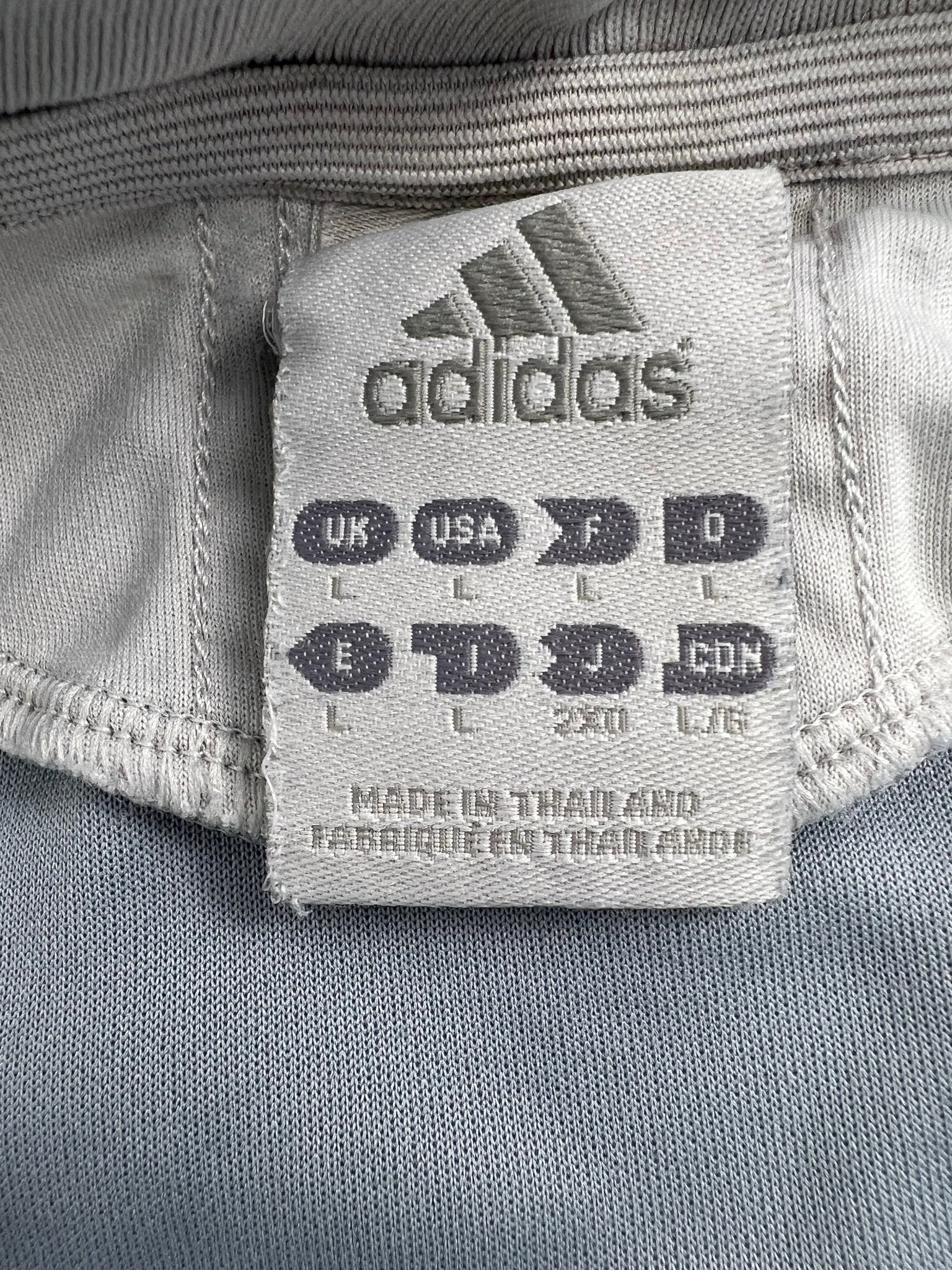 Close-up of adidas clothing label showing size large