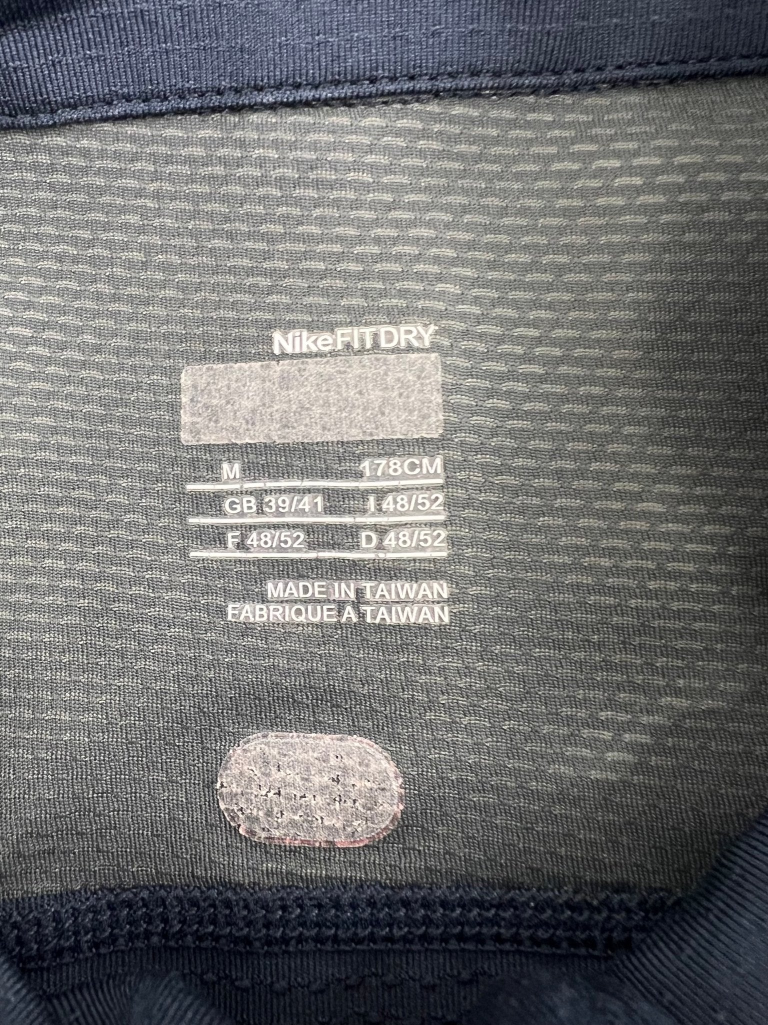 Nike FIT DRY label showing medium size and fabric information inside the top