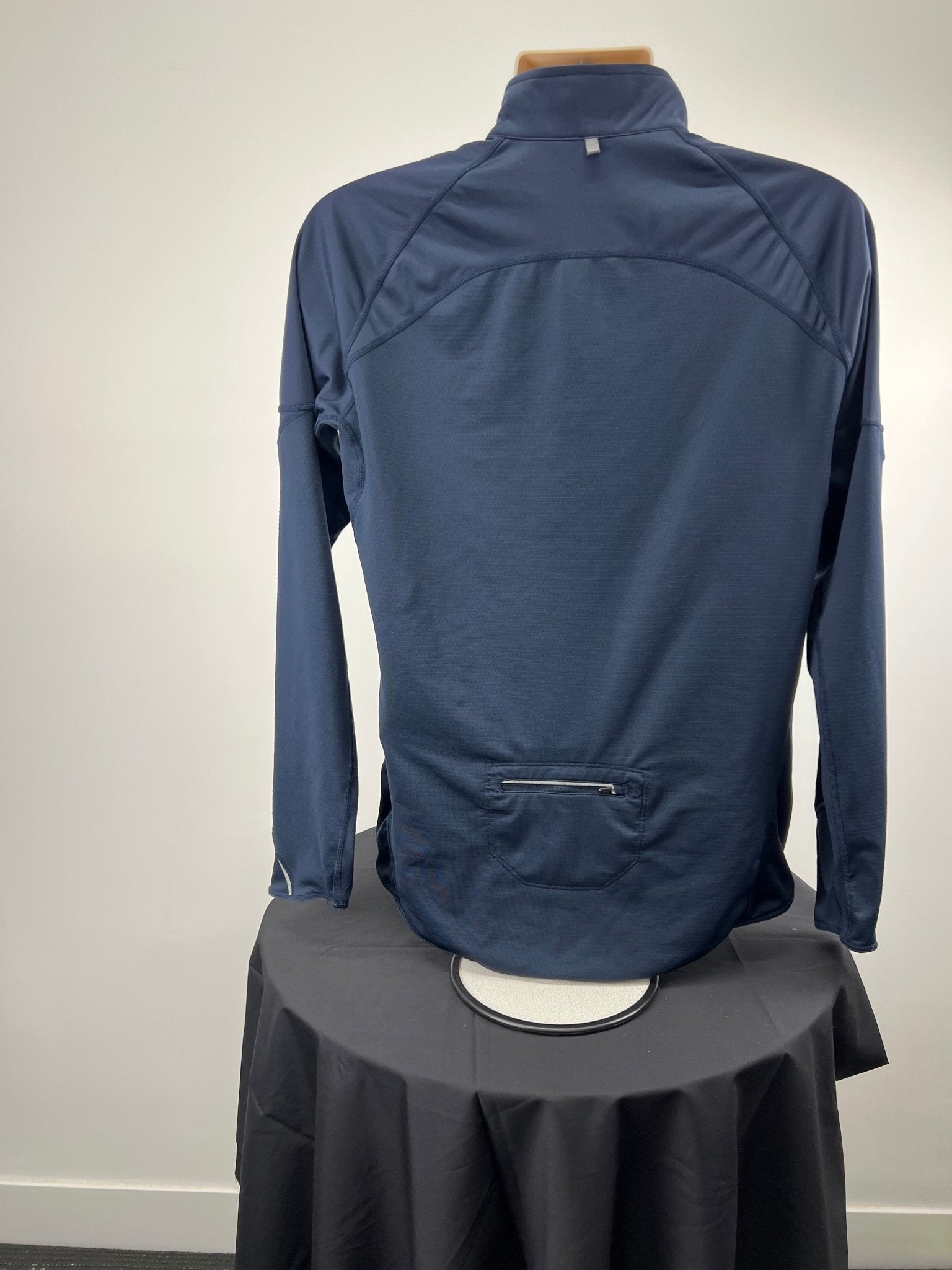 Back view of dark blue Nike Dri-FIT 1/2 zip running top showing zip pocket detail
