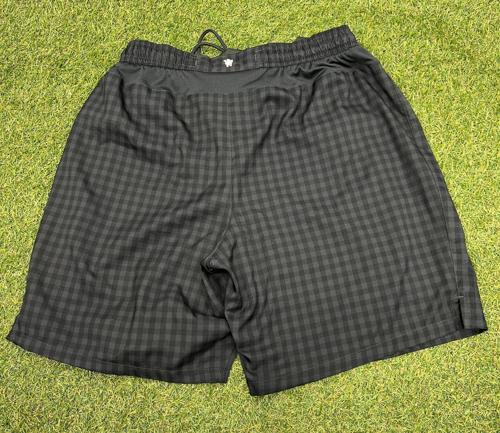 Rear view of black Nike dri fit Manchester United shorts with check pattern, size XL