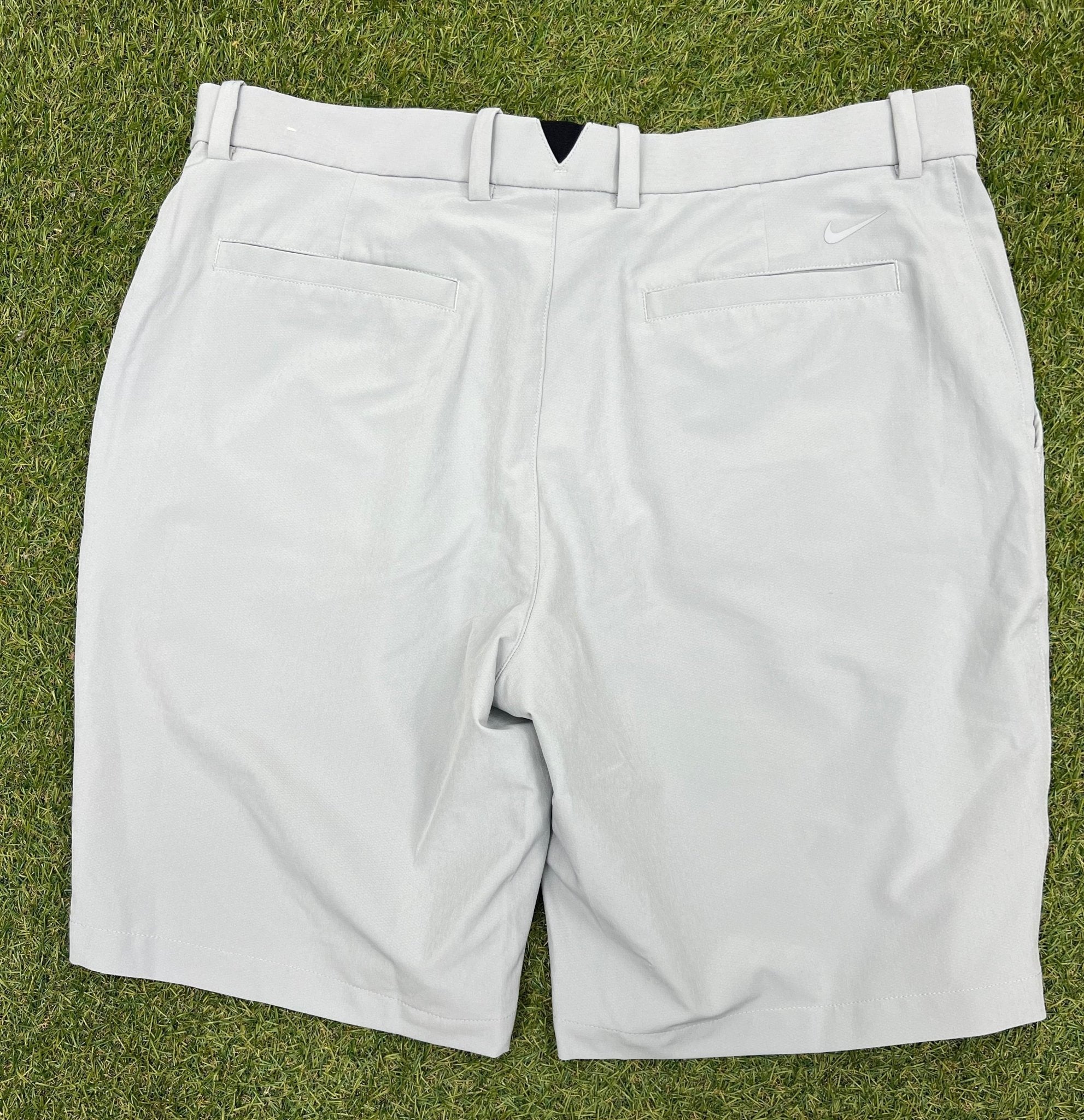Back view of grey Nike golf shorts showing pockets and small Nike logo