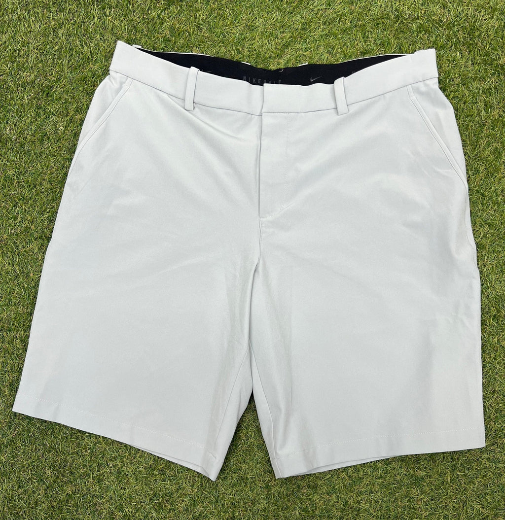 Front view of grey Nike golf shorts on grass