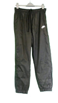 Black Nike waterproof joggers with white logo, displayed on hanger