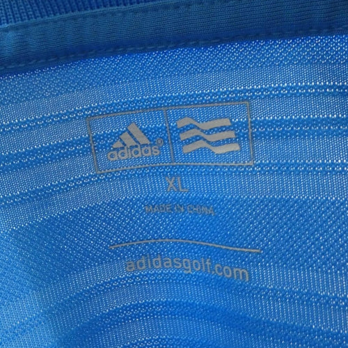 Close-up of Adidas branding, size XL label, and blue performance fabric texture