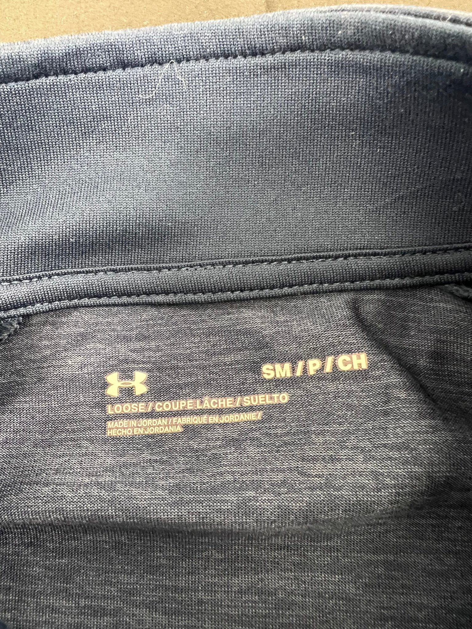 Size and material label of Under Armour 1/2 zip top showing small size and loose fit