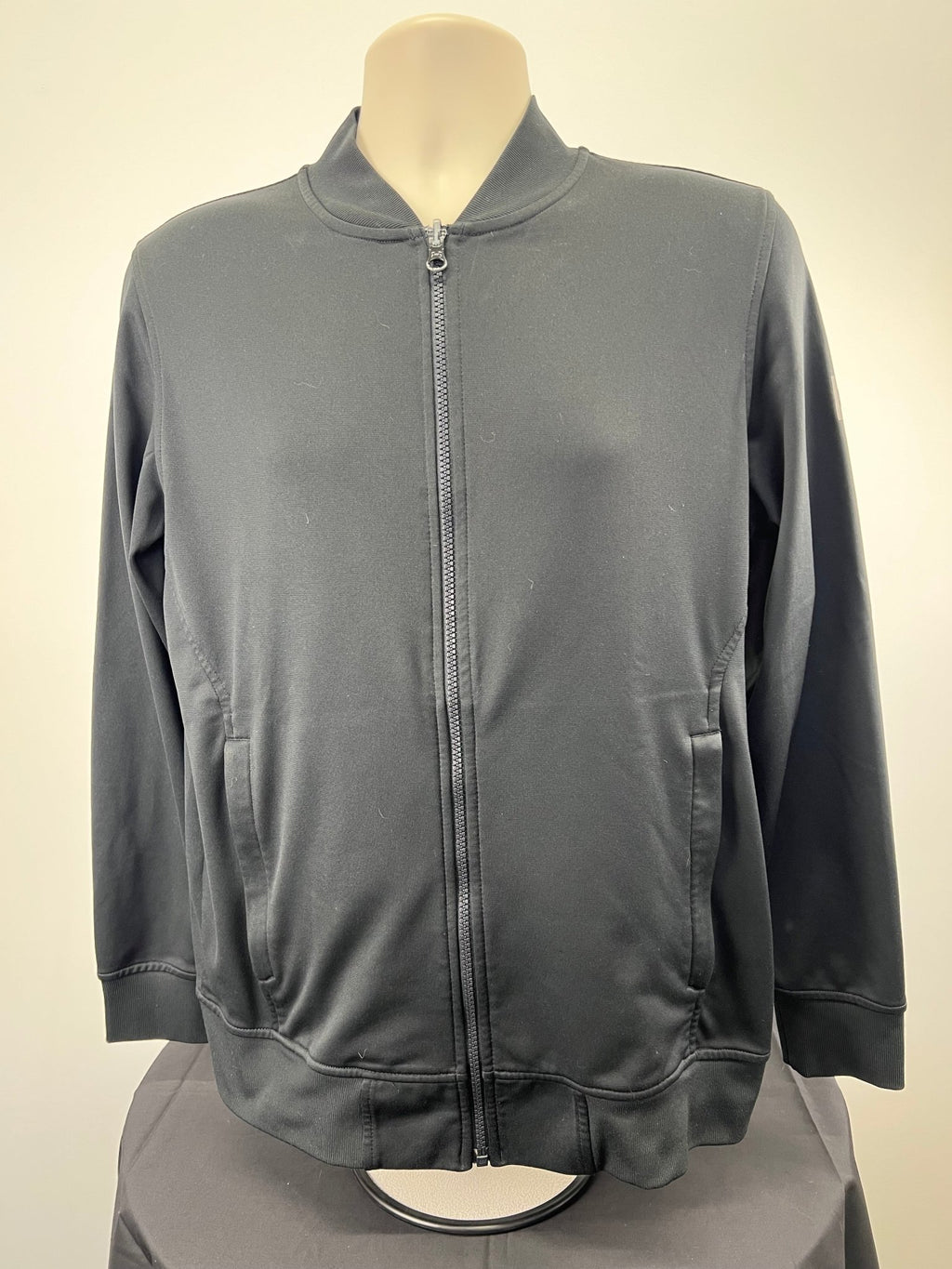 Front view of men's black Under Armour loose fitting jacket, size medium