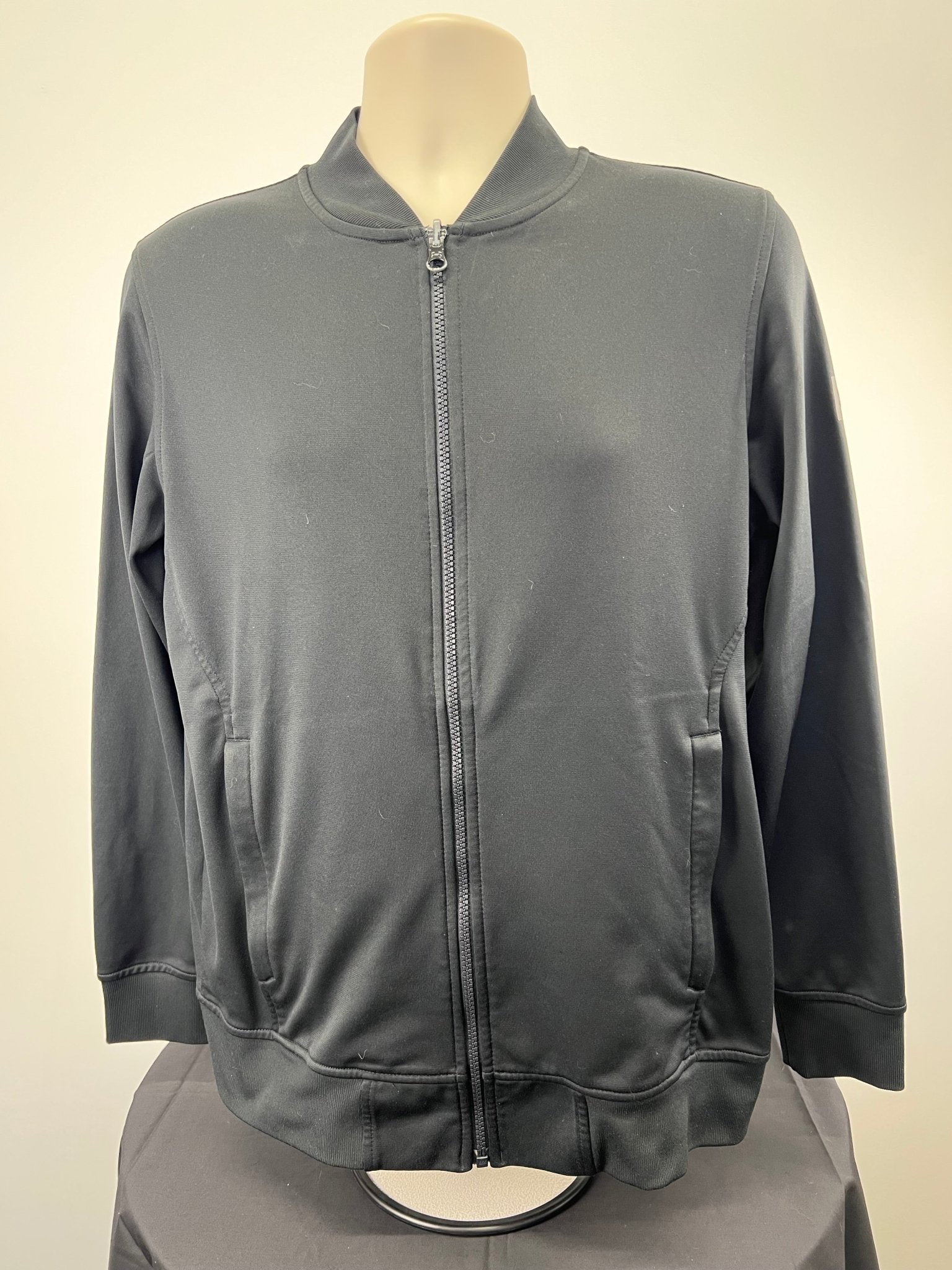 Front view of men's black Under Armour loose fitting jacket, size medium