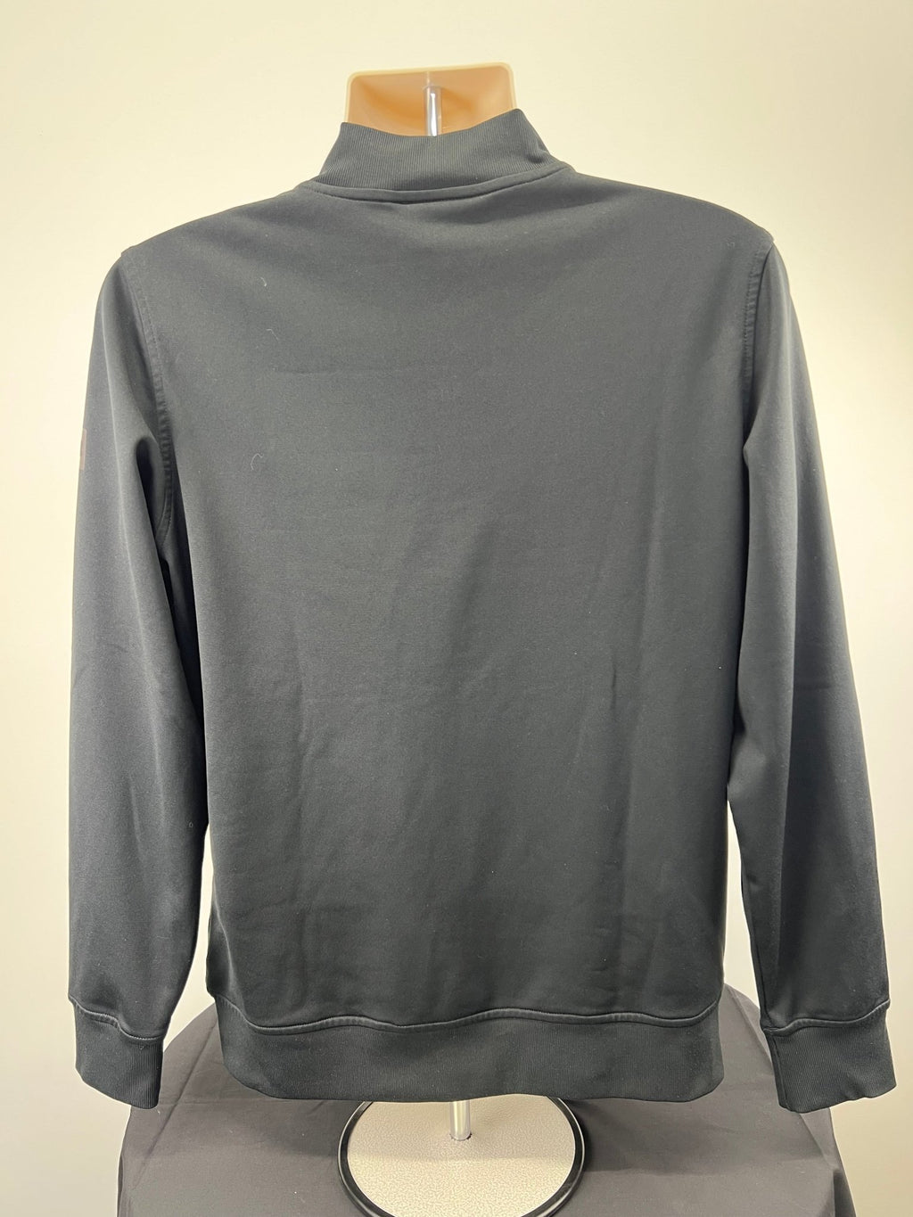 Rear view of men's black Under Armour loose fitting jacket, size medium