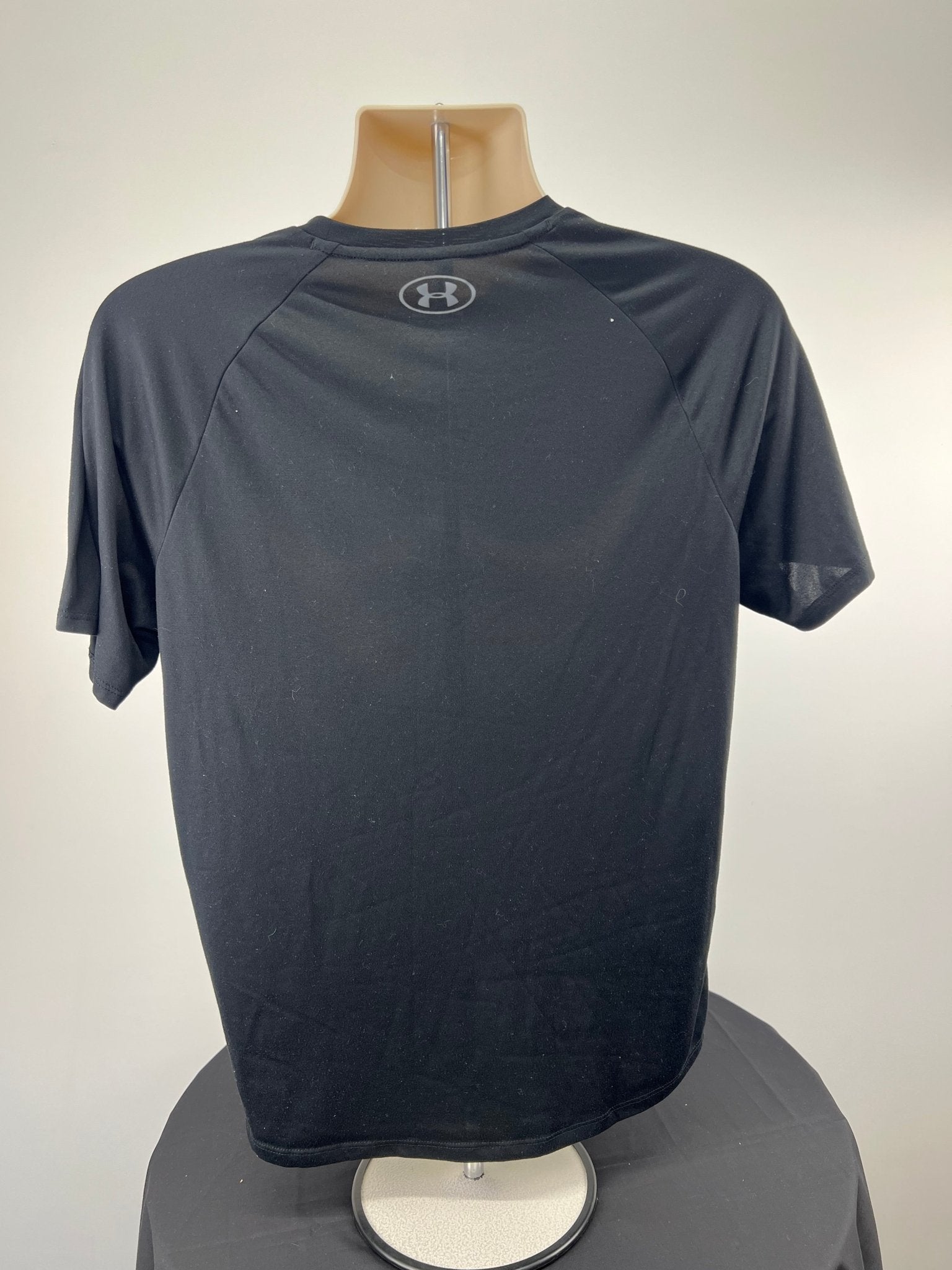 Back view of Under Armour black tech tee in size medium displayed on a mannequin