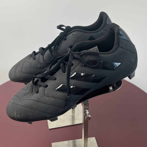 Side view of Adidas black football boots showing logo and design