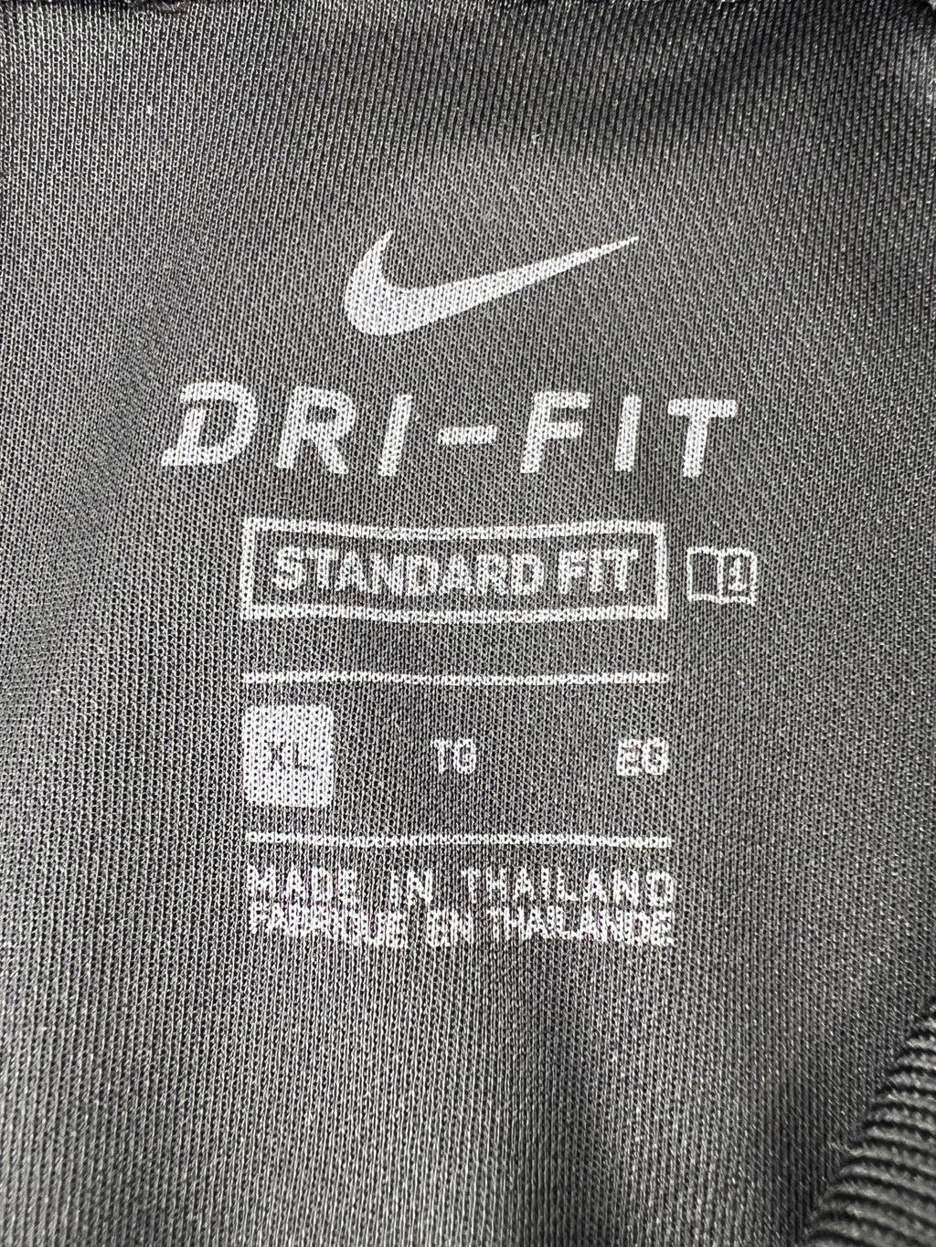 Close-up of Nike Dri-FIT XL label inside black golf polo shirt