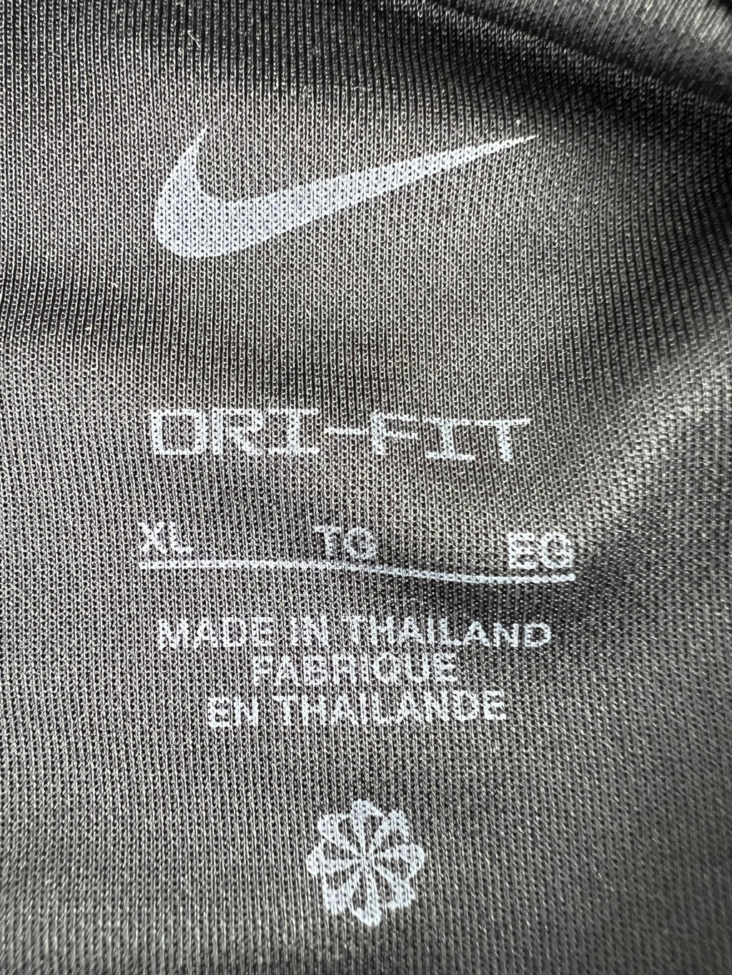 Close-up of Nike Dri-FIT tag inside black polo shirt