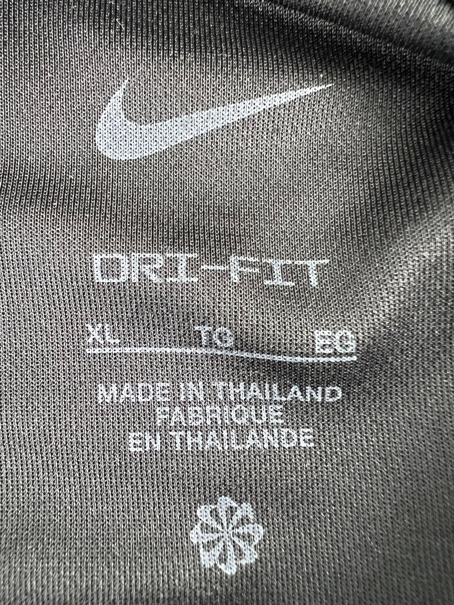 Close-up of Nike Dri-FIT tag inside black polo shirt