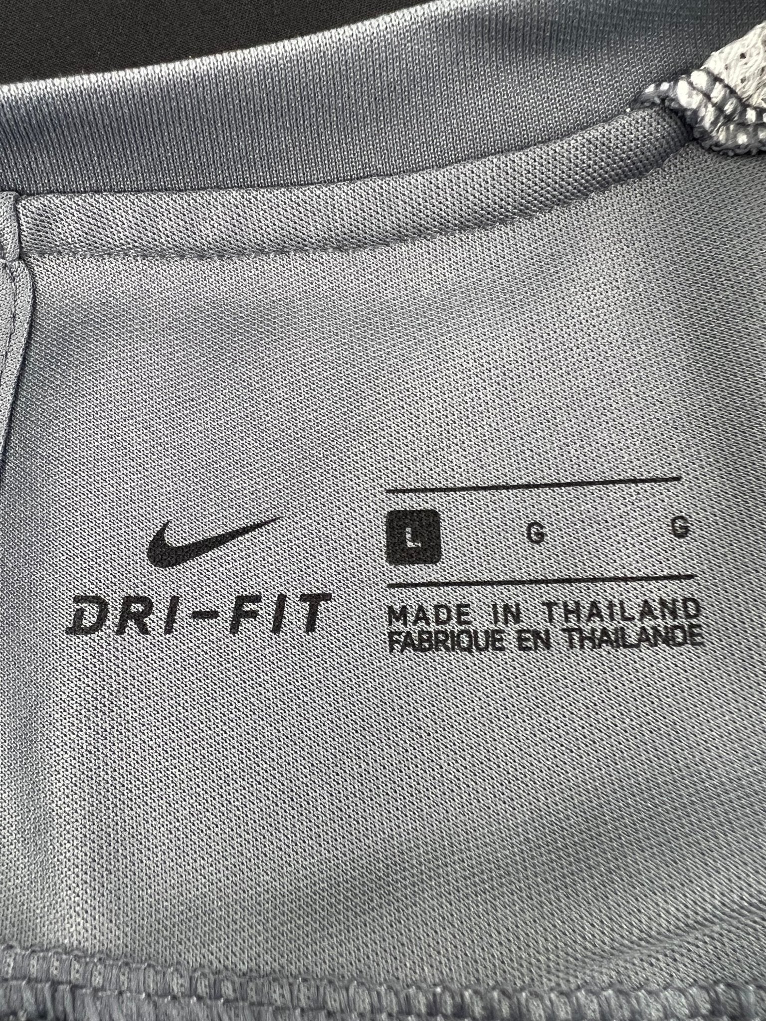 Close-up of Nike Dri-FIT tag and size label inside collar
