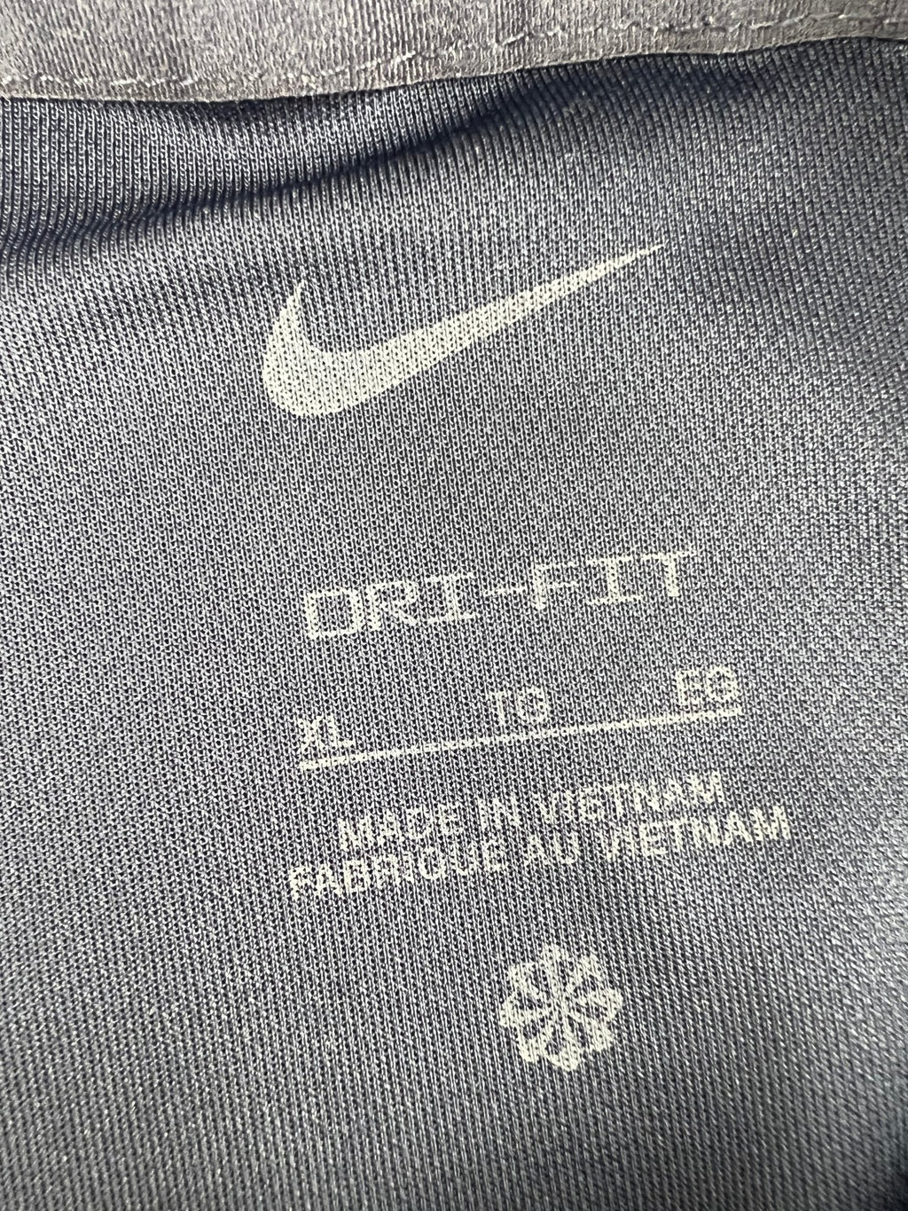 Nike Dri-FIT polo inside tag showing size XL and material details