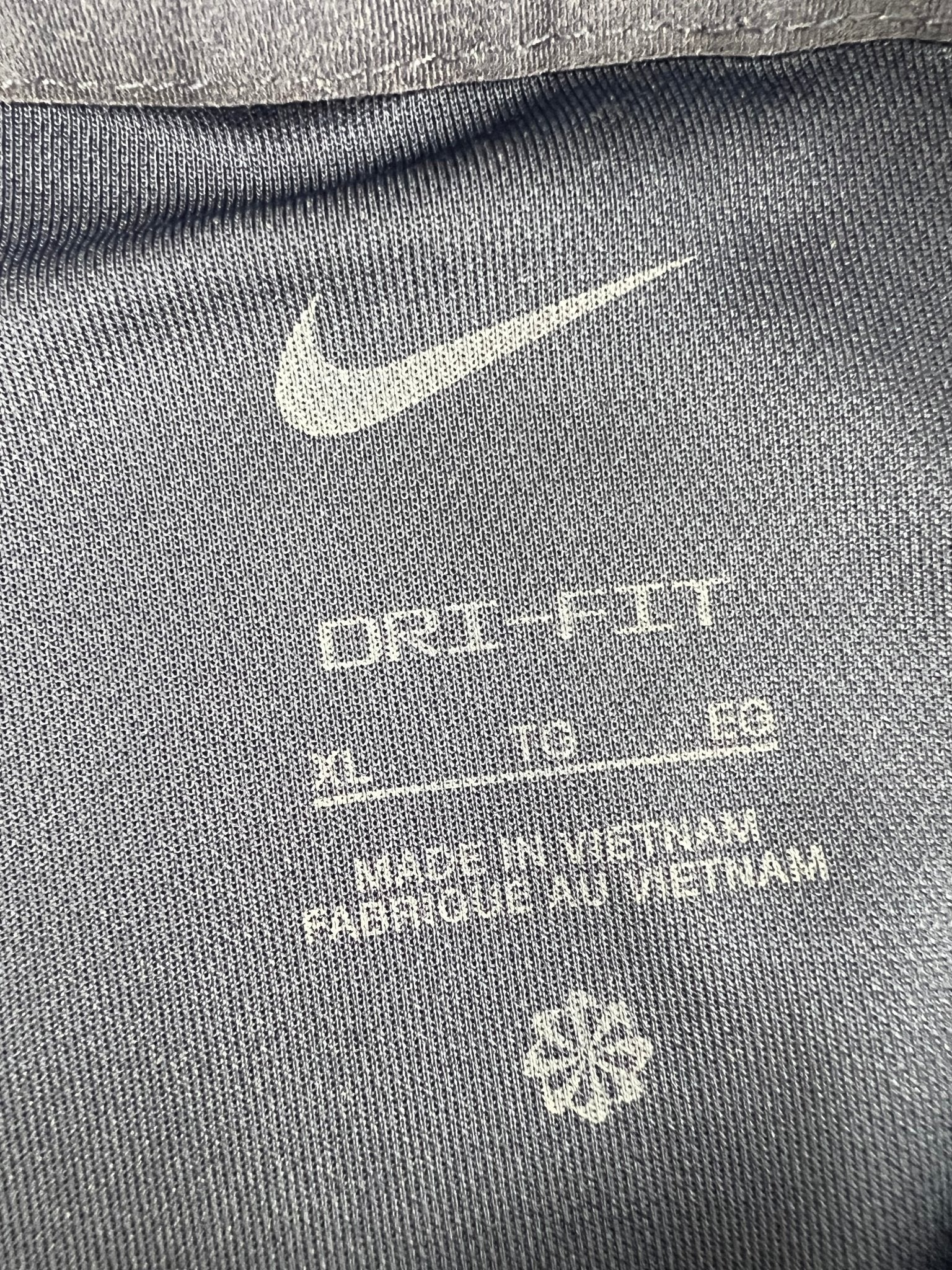 Nike Dri-FIT polo inside tag showing size XL and material details
