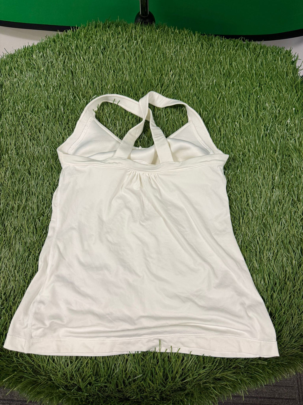 Back view of Nike Dri-FIT women's white tennis top showing the cross-back strap design