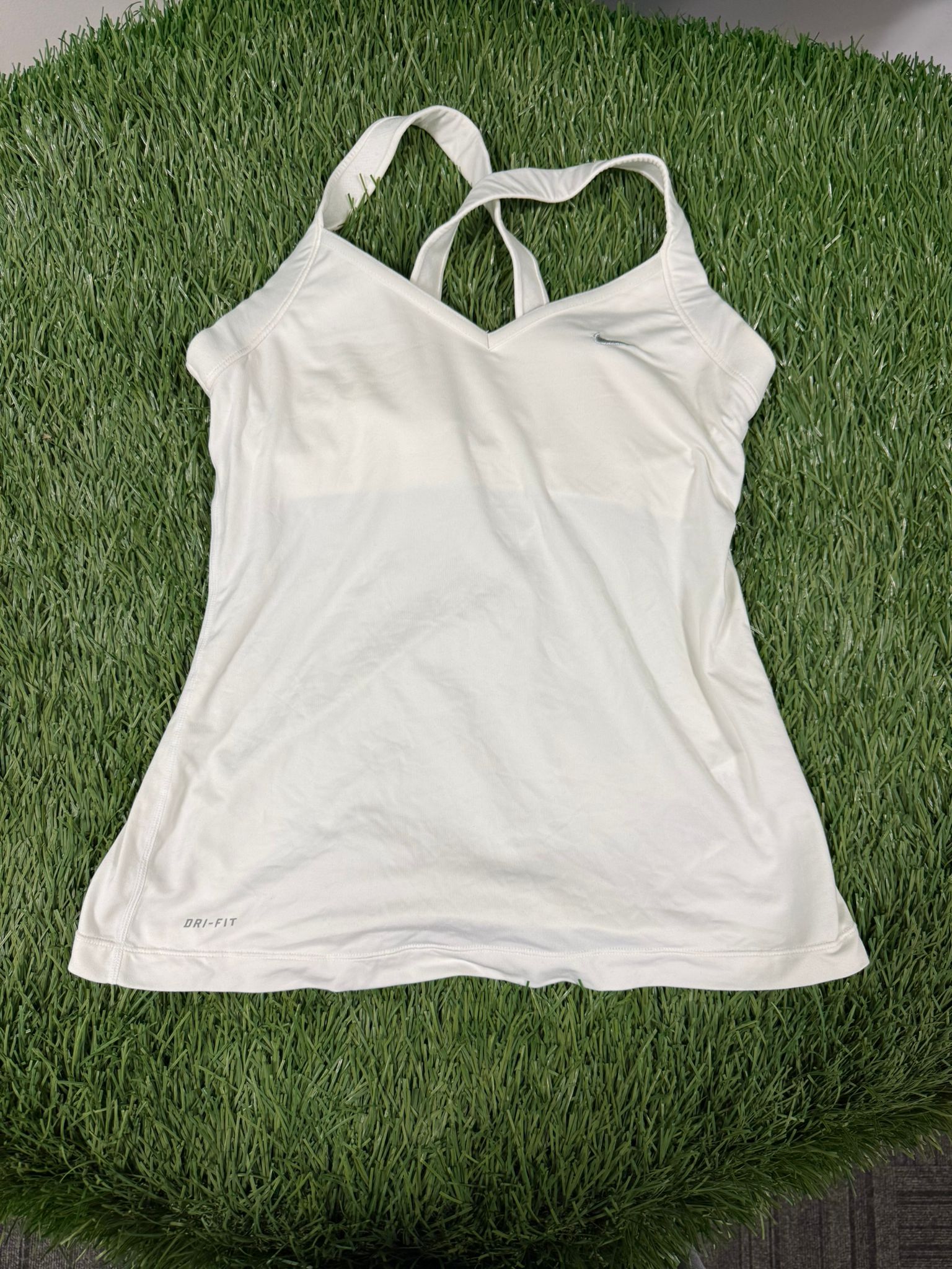 Front view of Nike Dri-FIT women's white tennis top with v-neck and cross-back straps