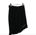 Black Nike Dri-FIT football shorts hanging against kitround backdrop
