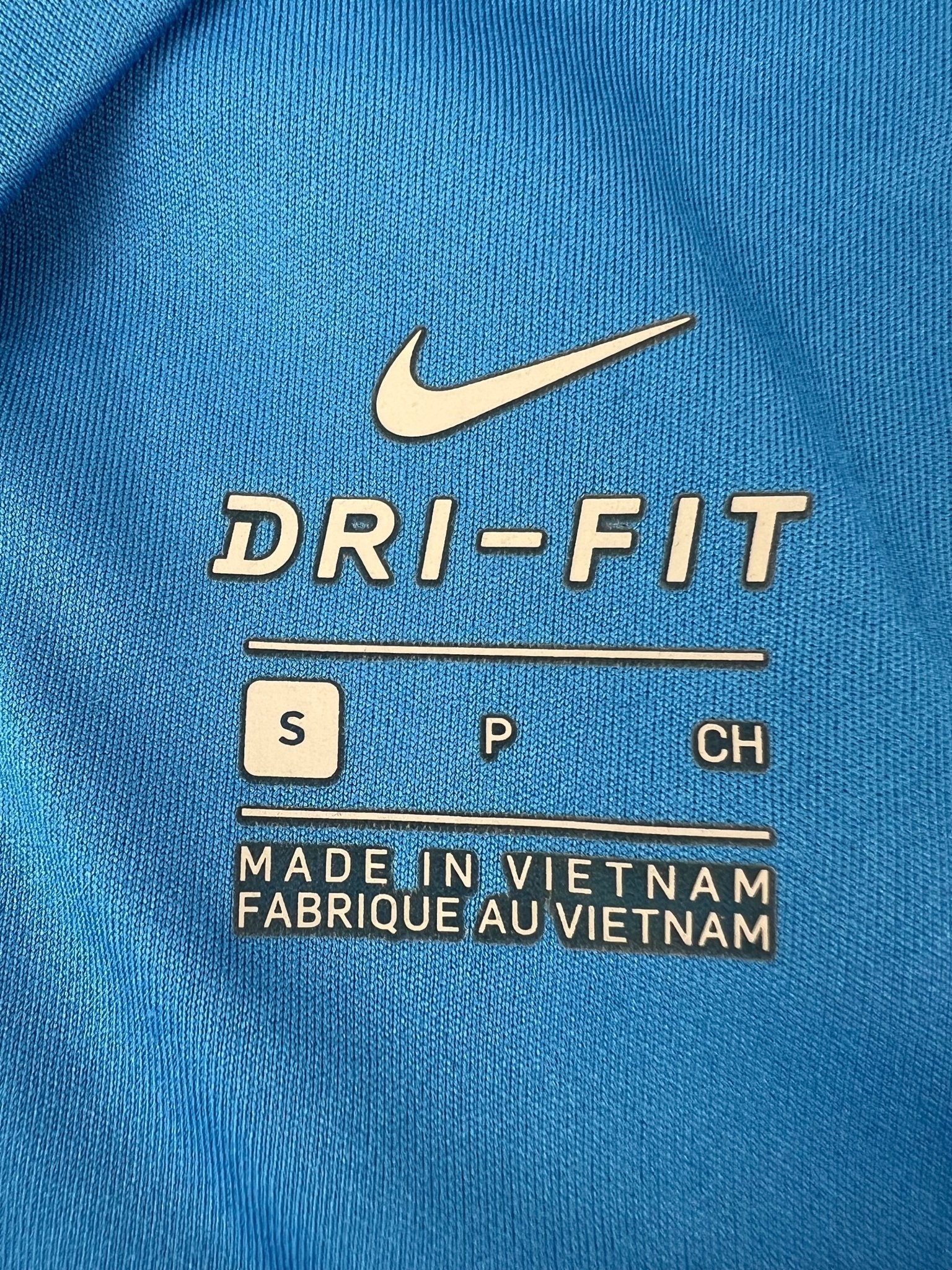 Close-up of Nike Dri-FIT fabric label showing size and manufacturing details