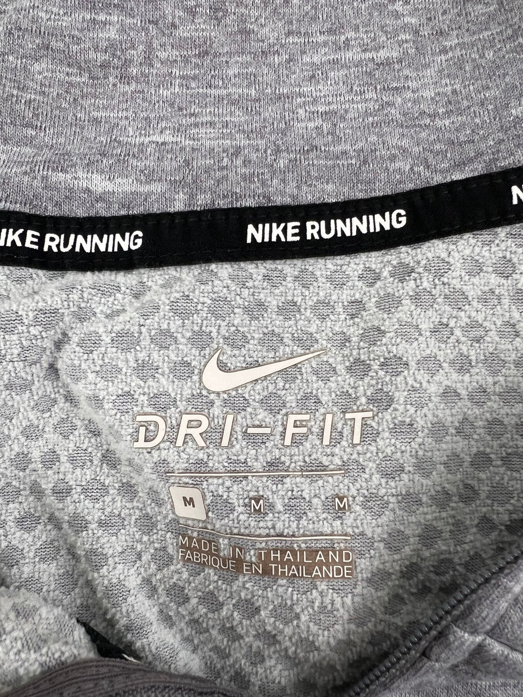 Close-up of Nike Dri-Fit label inside grey hoodie