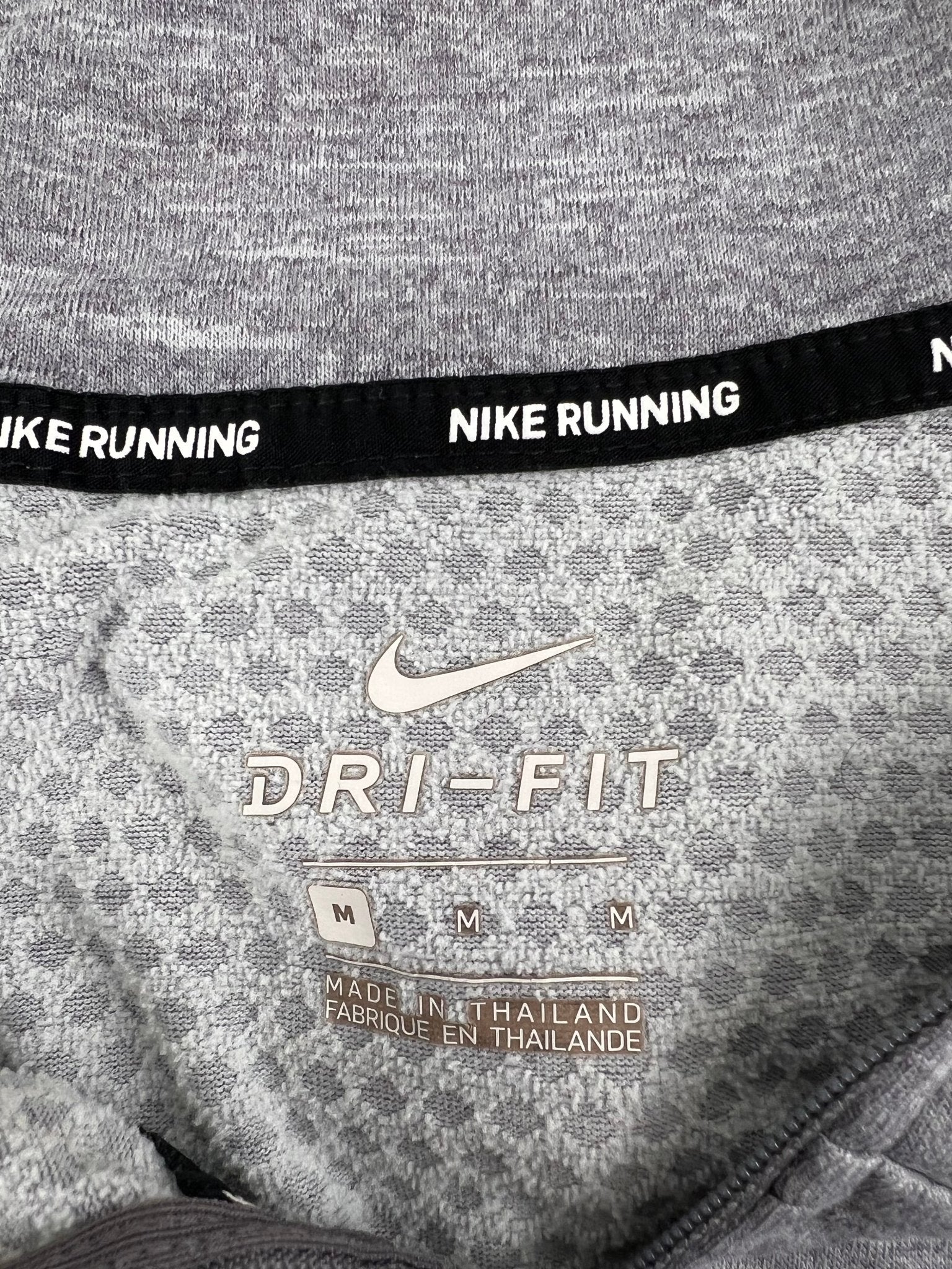Close-up of Nike Dri-Fit label inside grey hoodie